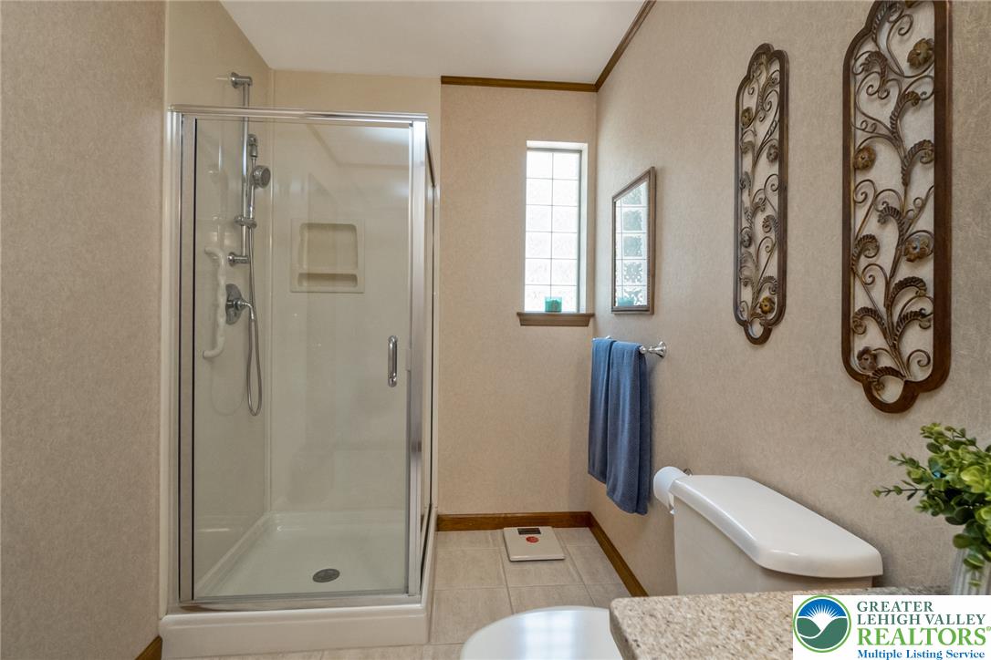 2298 Yost Road Bath, PA 18014 - Photo 28 of 33 A well-appointed bathroom features a glass-enclosed shower alongside a granite-topped vanity.