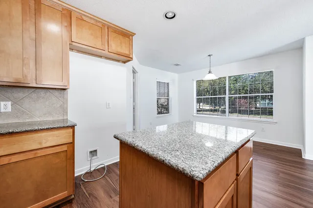 a kitchen with granite countertop kitchen island a counter space and a sink