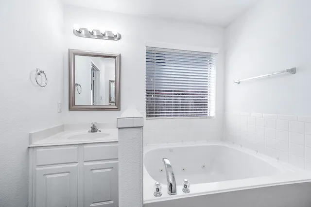 a bathroom with a bathtub sink and mirror