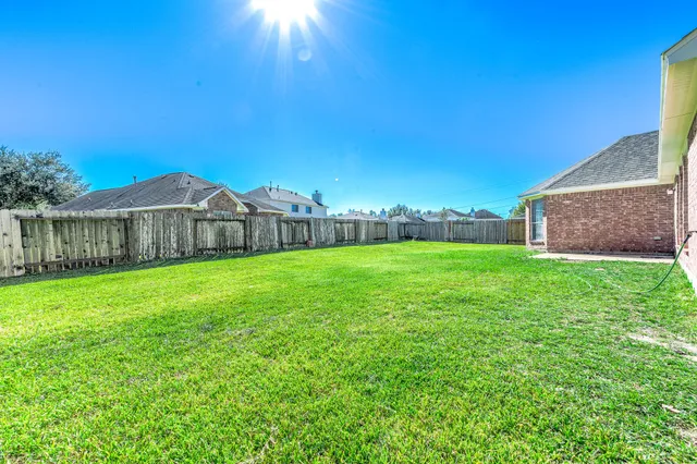 a view of a house with a big yard and large tree