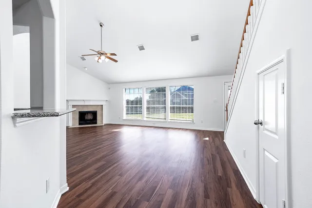 a view of empty room with wooden floor and fireplace