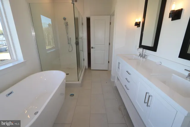 a bathroom with a double vanity sink a mirror and a bathtub