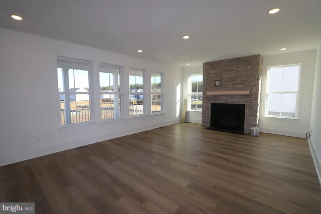 an empty room with wooden floor and fireplace
