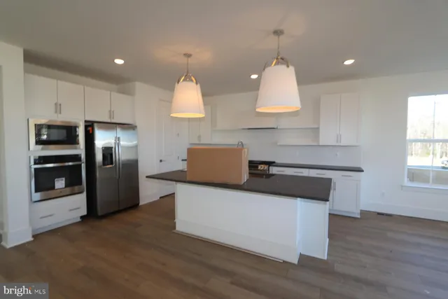 a kitchen with stainless steel appliances a stove refrigerator sink and microwave