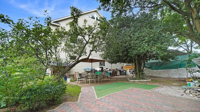 a view of a backyard with table and chairs under an umbrella