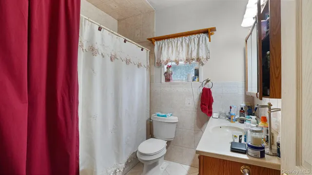 a bathroom with a toilet sink and shower curtain