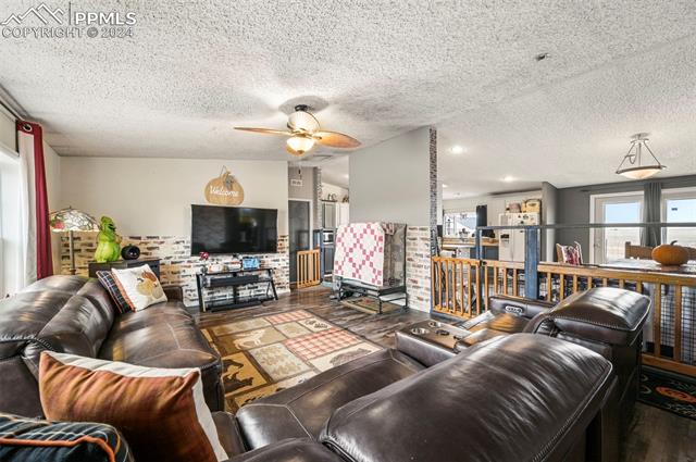 3010 Old Windmill View Yoder, CO 80864 - Photo 3 of 19 Living room with hardwood / wood-style floors, a textured ceiling, and ceiling fan