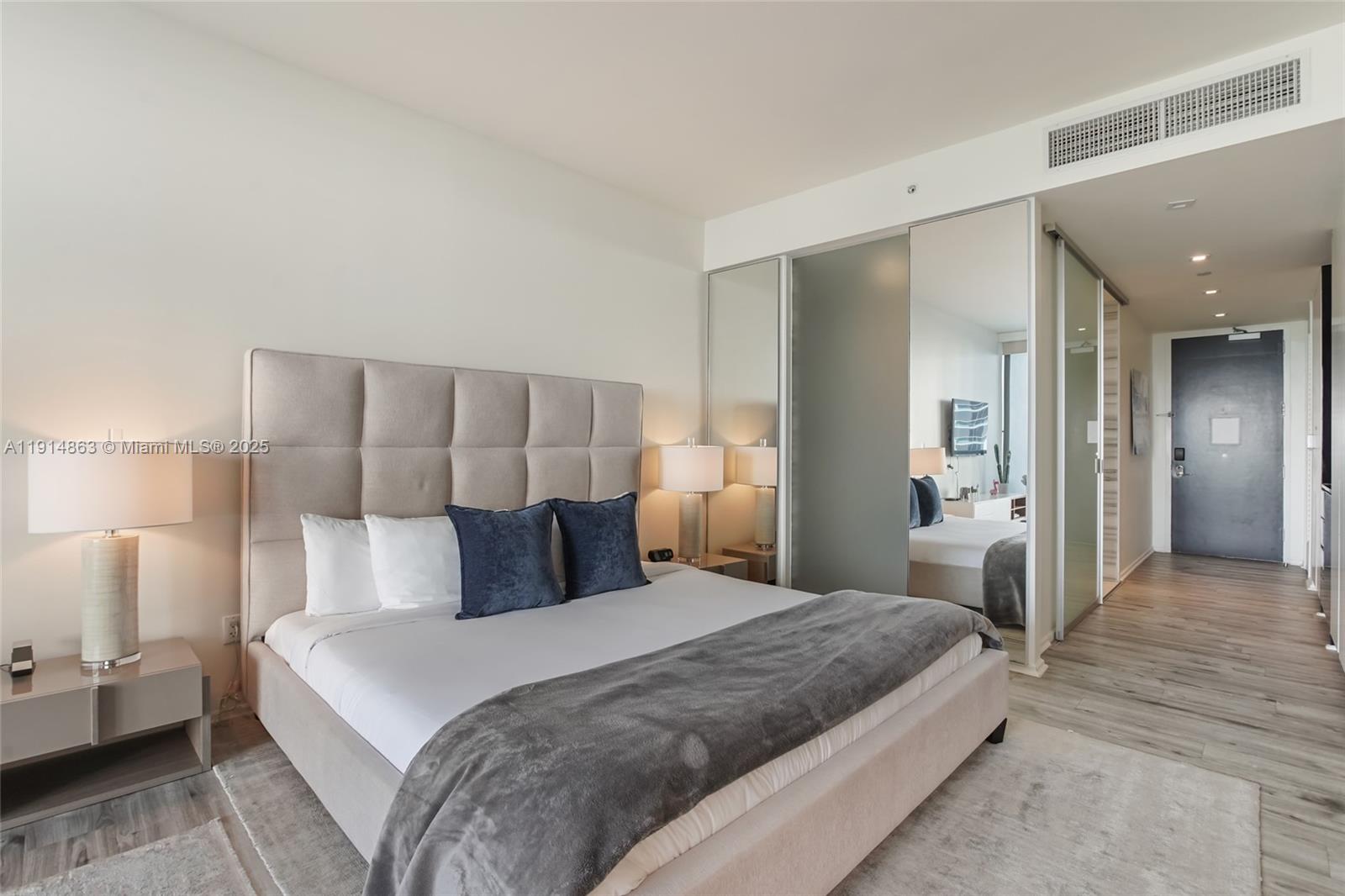 2201 Collins Avenue, Unit 523 Miami Beach, FL 33139 - Photo 11 of 18 a bedroom with a bed and a lamp