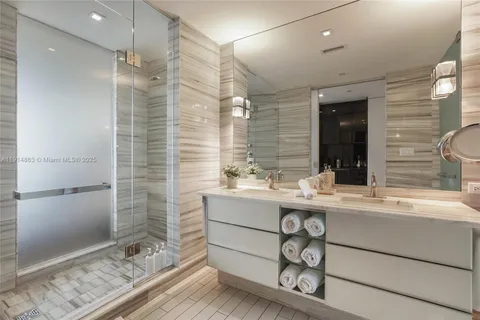 a bathroom with a double vanity sink mirror and shower