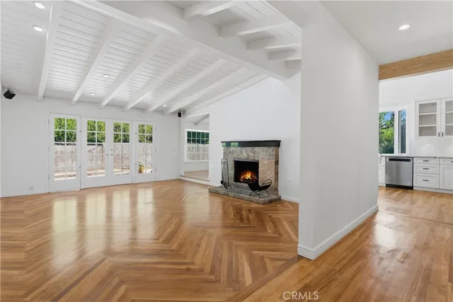 a view of empty room with wooden floor and fireplace
