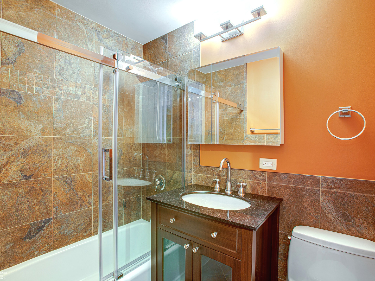 1700 East 56th Street, Unit 2907 Chicago, IL 60637 - Photo 12 of 17 a bathroom with a granite countertop sink a mirror and a shower