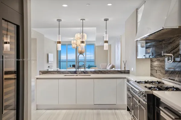 a kitchen with stainless steel appliances granite countertop a sink a stove and a refrigerator