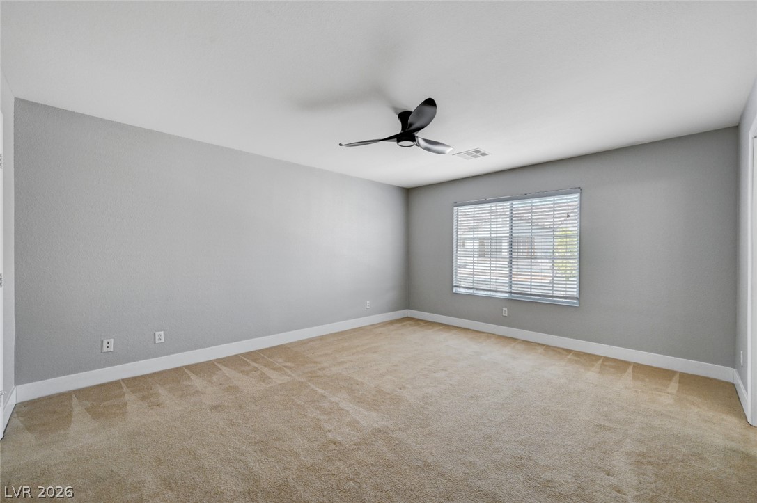 7259 Cestrum Road Las Vegas, NV 89113 - Photo 15 of 35 An airy bedroom with soft carpet flooring and a modern ceiling fan, awaiting your personal touch.