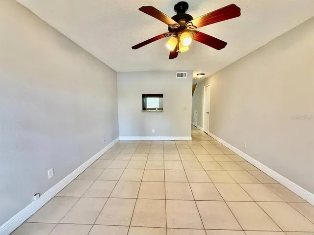 an empty room with windows and fan