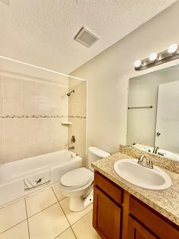 a bathroom with a granite countertop sink a toilet and shower