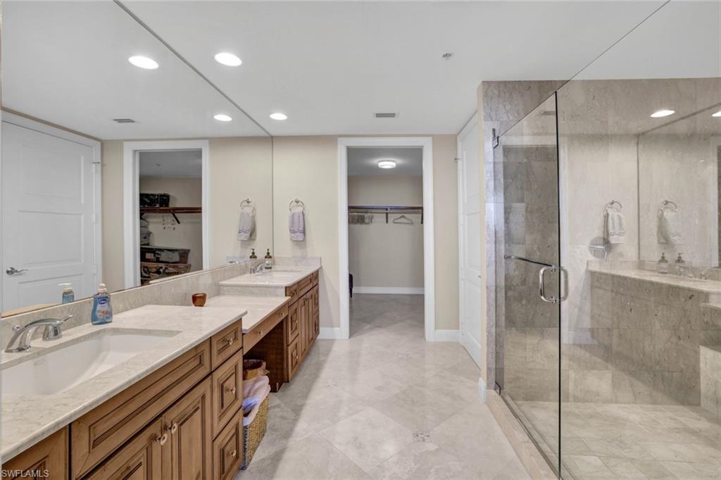 265 Indies Way, Unit 904 Naples, FL 34110 - Photo 11 of 19 a large bathroom with a double vanity sink shower and mirror