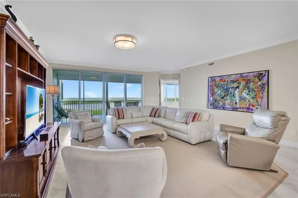 a living room with furniture a large window and a flat screen tv