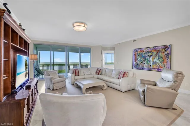 a living room with furniture a large window and a flat screen tv
