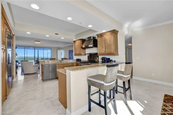 a kitchen with stainless steel appliances kitchen island granite countertop a refrigerator a stove a sink dishwasher with a dining table and chairs