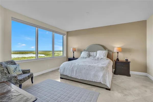a bedroom with a bed and large window