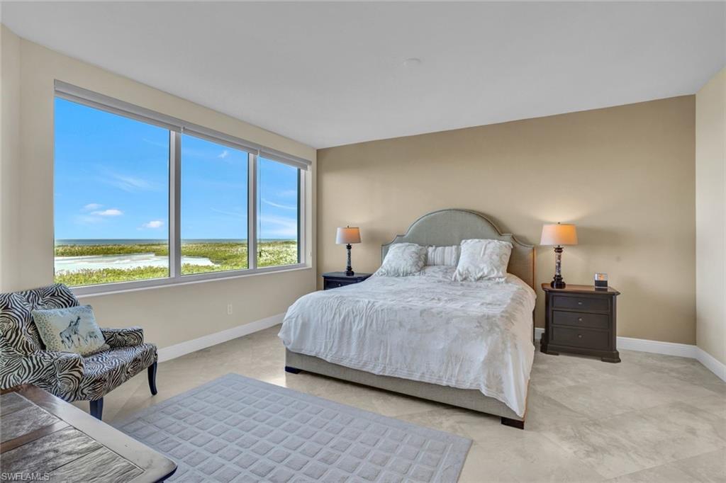 265 Indies Way, Unit 904 Naples, FL 34110 - Photo 9 of 19 a bedroom with a bed and large window