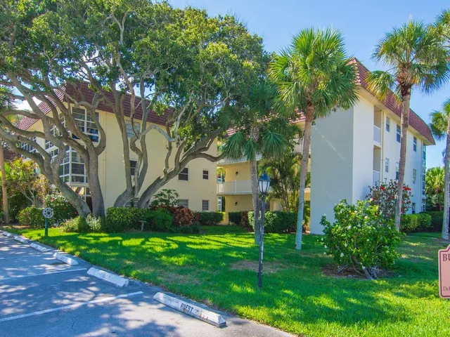 a view of a house with a big yard and large trees