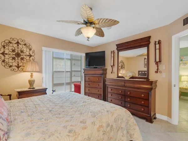 a bedroom with a bed and a flat tv screen on dresser