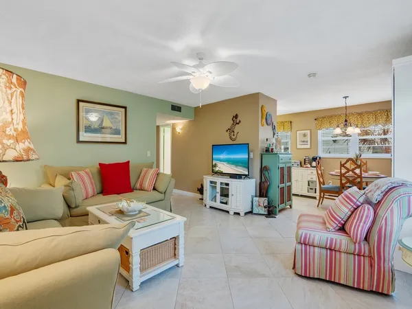 a living room with furniture a flat screen tv and a window