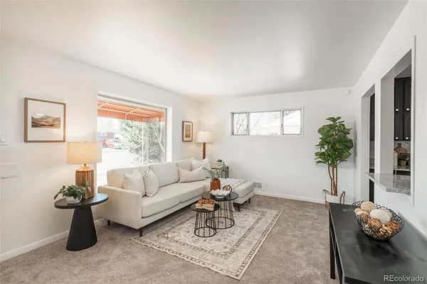 a living room with furniture a window and a potted plant
