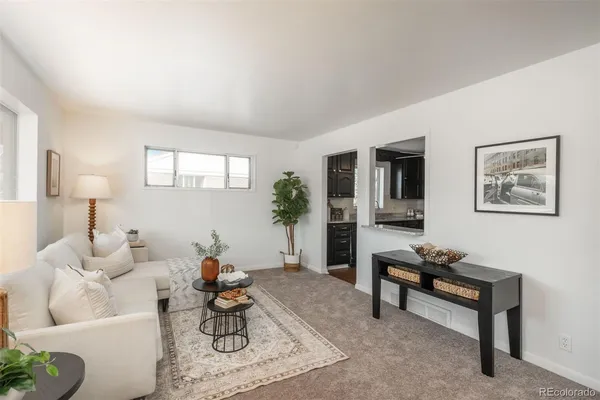 a living room with furniture a rug and a lamp