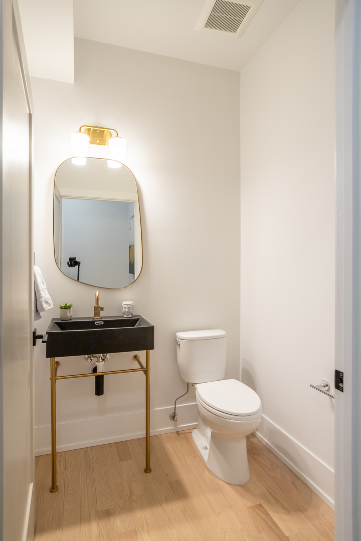 2228 West Lyndale Street Chicago, IL 60647 - Photo 11 of 23 a bathroom with a toilet a sink and mirror