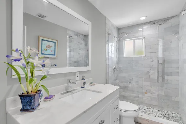 a bathroom with a sink a toilet and shower