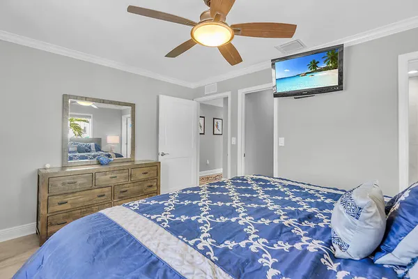 a bedroom with a bed and a chandelier fan