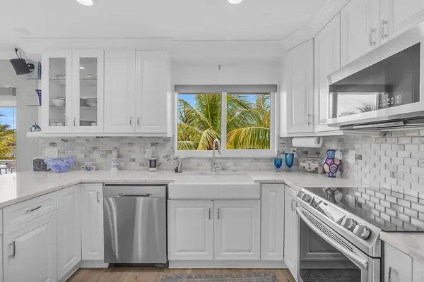 a kitchen with stainless steel appliances white cabinets and a stove top oven