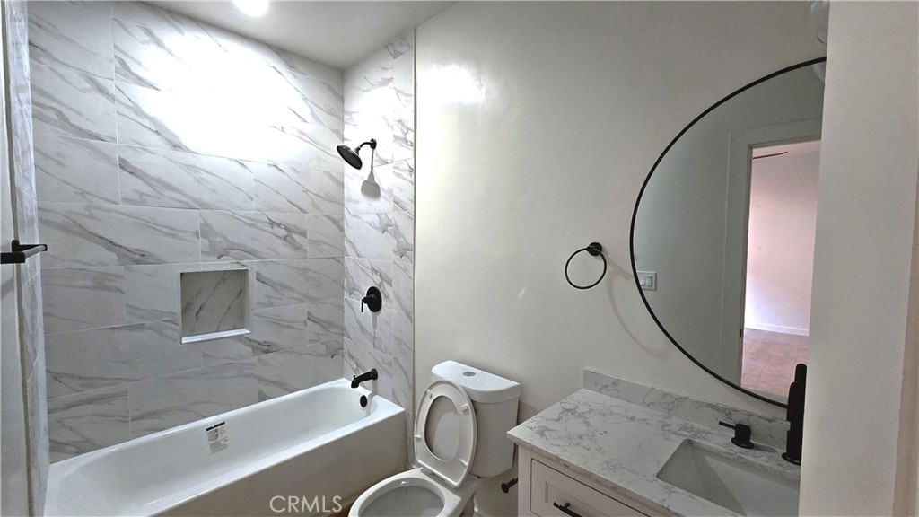 11171 Bullis Road Lynwood, CA 90262 - Photo 5 of 15 a bathroom with a granite countertop sink a mirror and a shower