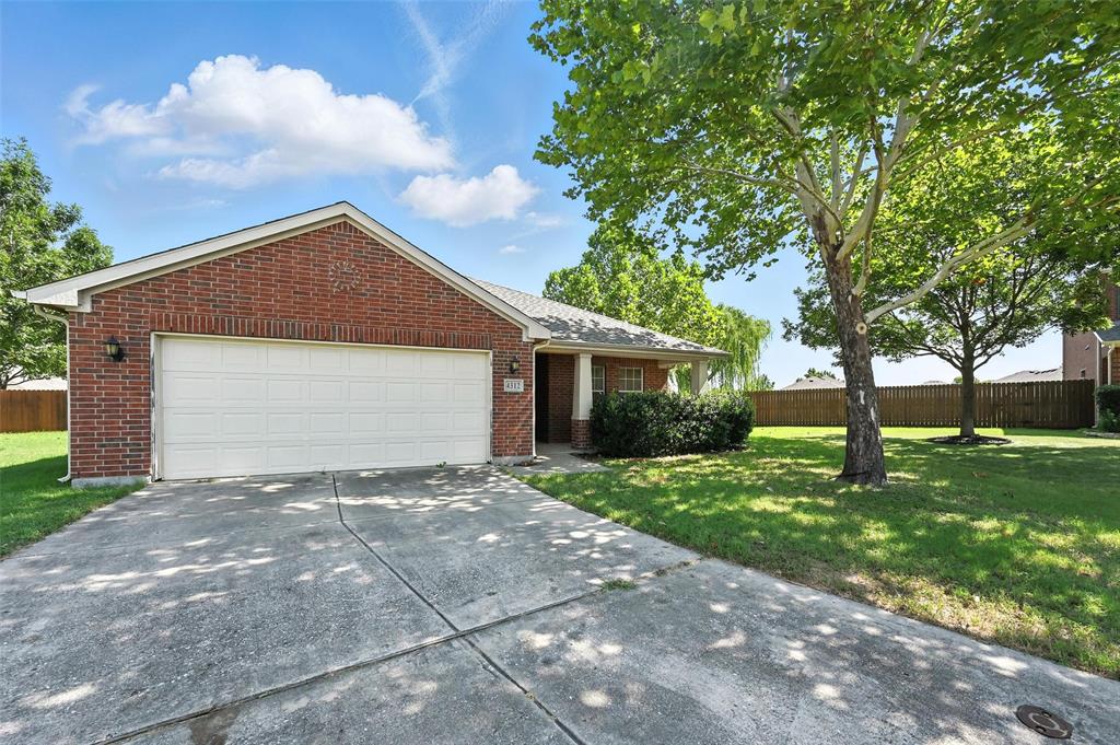 a front view of a house with a garden and trees