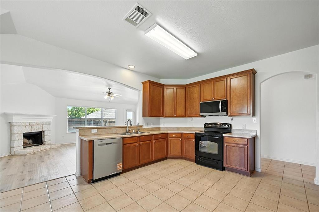 4312 Ridgewood Road Melissa, TX 75454 - Photo 15 of 40 a kitchen with stainless steel appliances granite countertop a stove sink and cabinets