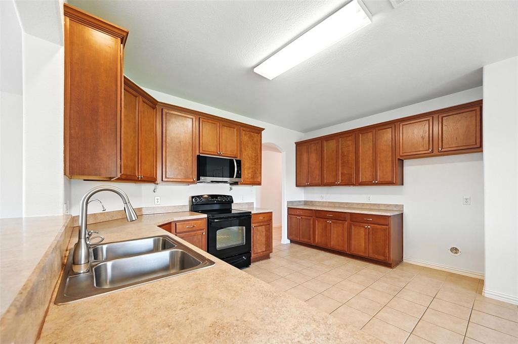 4312 Ridgewood Road Melissa, TX 75454 - Photo 16 of 40 a kitchen with stainless steel appliances granite countertop a stove top oven a sink and dishwasher