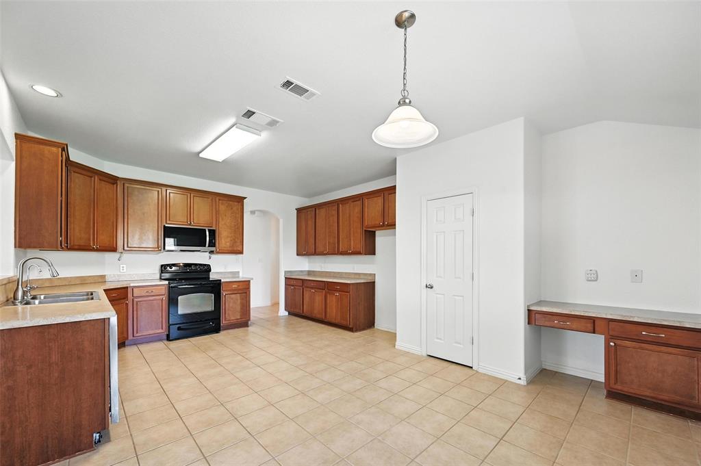 4312 Ridgewood Road Melissa, TX 75454 - Photo 18 of 40 a kitchen with stainless steel appliances granite countertop a sink a stove and a refrigerator