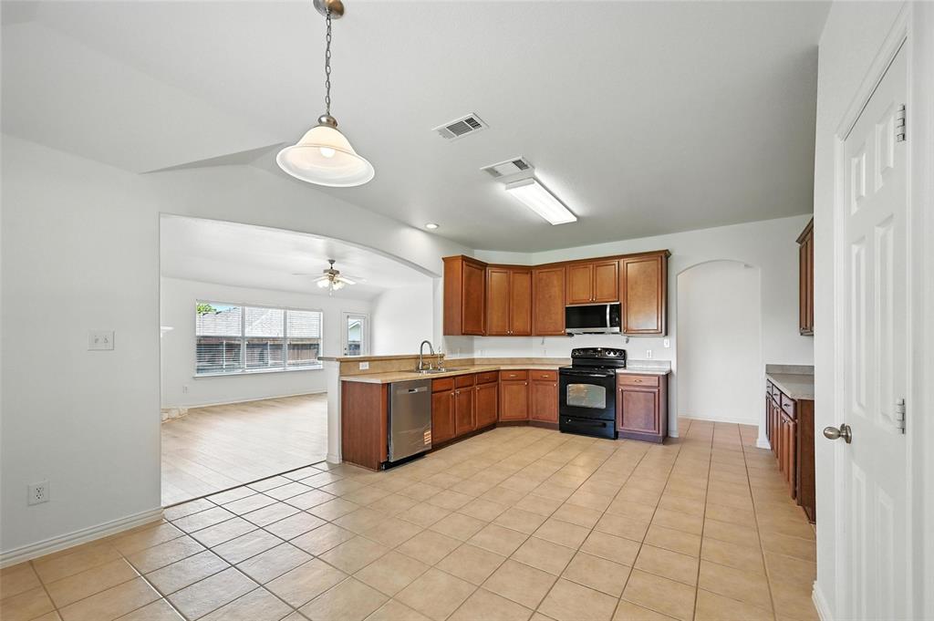 4312 Ridgewood Road Melissa, TX 75454 - Photo 19 of 40 a large kitchen with a large counter top space a sink stainless steel appliances and cabinets