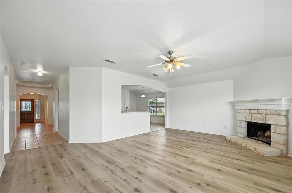 4312 Ridgewood Road Melissa, TX 75454 - Photo 22 of 40 a view of an empty room with wooden floor and a fireplace