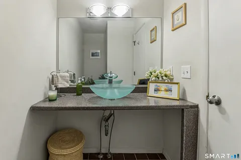 a bathroom with a granite countertop sink a toilet and mirror
