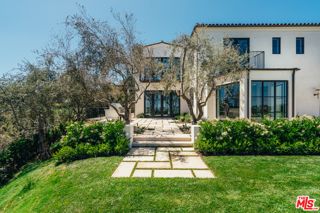 375 Fordyce Road Los Angeles, CA 90049 - Photo 22 of 26 a view of a white house with a yard and plants