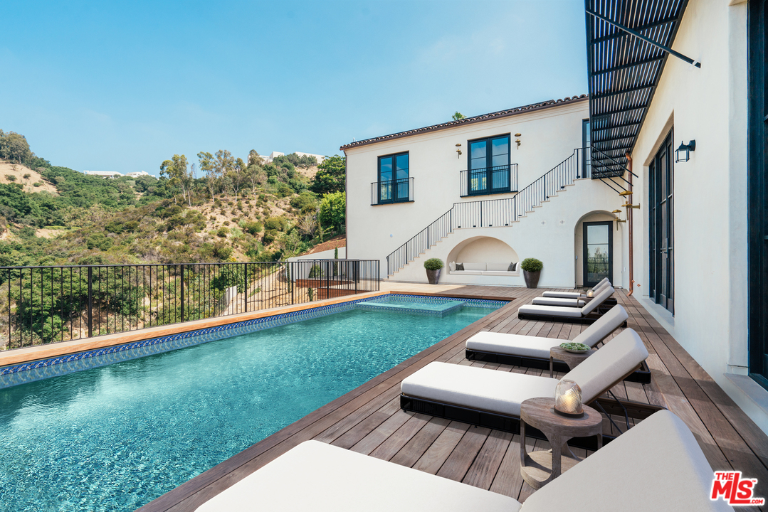 375 Fordyce Road Los Angeles, CA 90049 - Photo 24 of 26 a view of a patio with lawn chairs floor to ceiling window and lake view