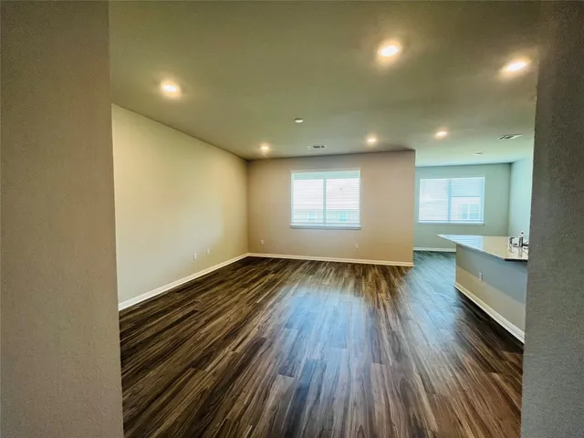 a large kitchen with stainless steel appliances a large counter top a stove and a wooden floors