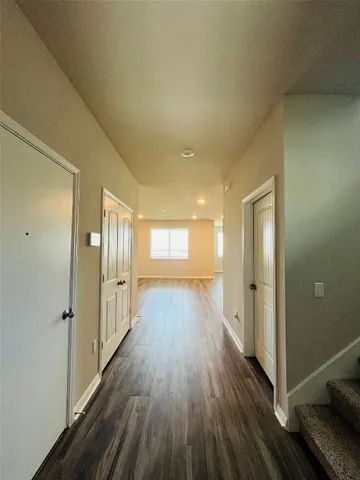 a view of a hallway with wooden floor and staircase