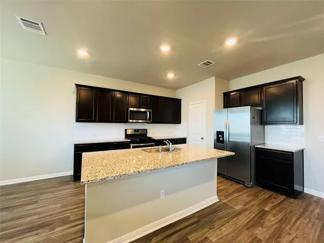 a view of a living room with flat screen tv and kitchen view