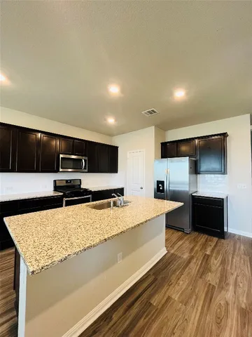 a kitchen with stainless steel appliances granite countertop a stove and a microwave