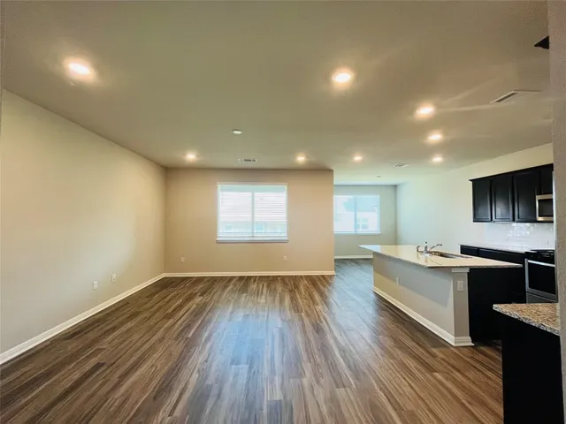 a large kitchen with stainless steel appliances kitchen island a large counter top and a stove top oven