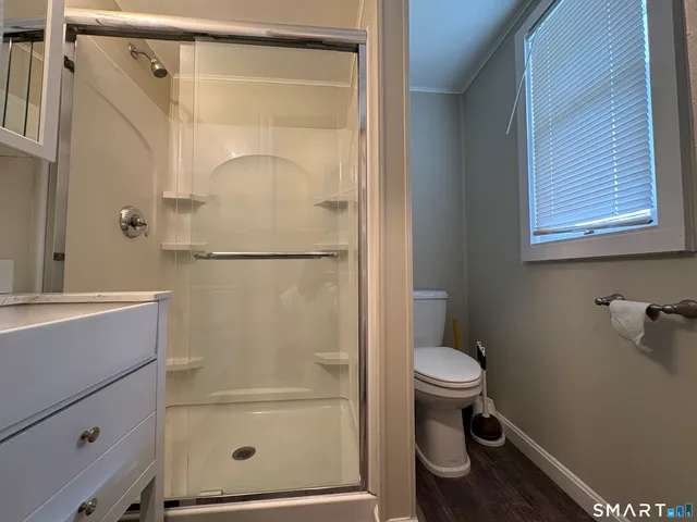 a bathroom with a granite countertop shower a toilet and sink